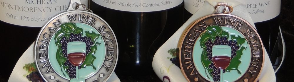 American Wine Society medals resting in front of bottles of Michigan fruit wine